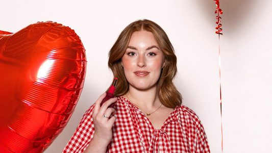Lived experience makeup artist, Anastasia, in headshot image with red outfit and white background.