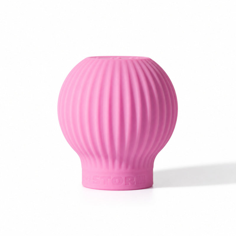 ByStorm Betty makeup grip in pink, a ribbed silicone ball with Braille on top, shaped to fill the palm for a fuller, steadier hold
