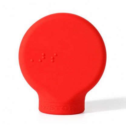 ByStorm Margie makeup grip in red, a flat silicone paddle with Braille on the front, for people whose fingers do not curl easily