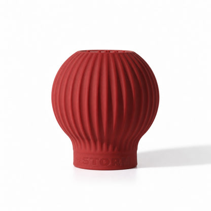 ByStorm Betty makeup grip in maroon, a ribbed silicone ball with Braille on top, shaped to fill the palm for a fuller, steadier hold