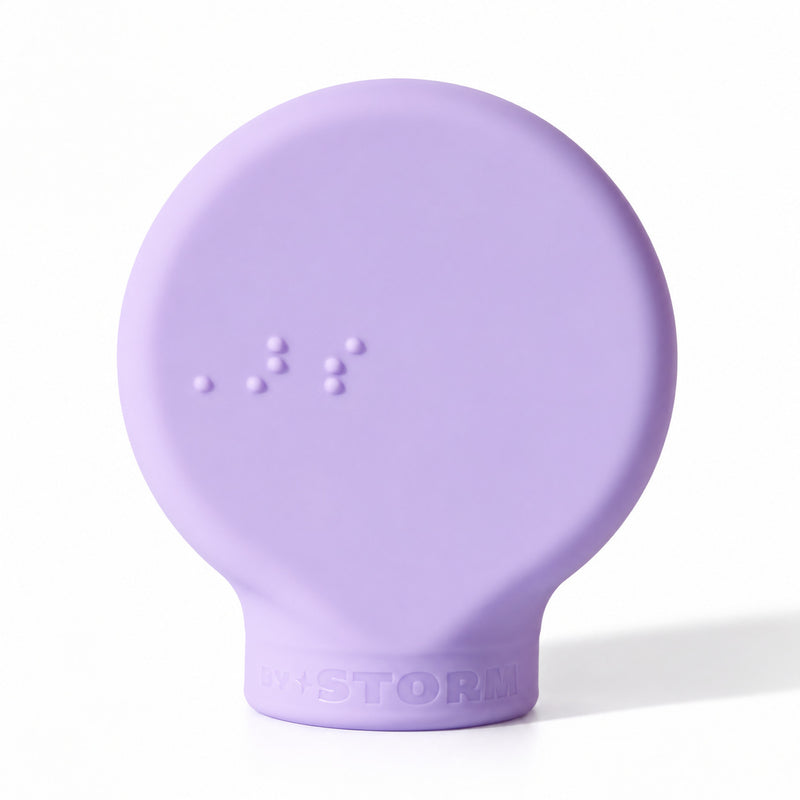 ByStorm Margie makeup grip in lilac, a flat silicone paddle with Braille on the front, for an open-hand hold