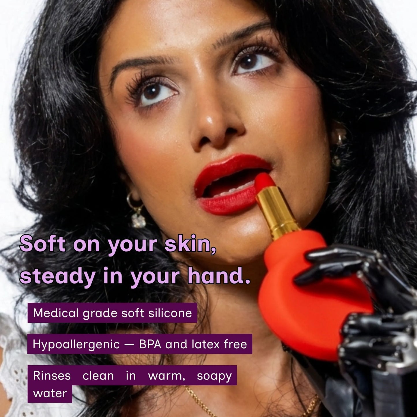 A close-up of a woman applying lipstick with a red paddle-shaped grip. The text reads,  Soft on your skin, steady in your hand, medical-grade soft silicone, hypoallergenic, BPA and latex-free. Rinse clean in warm soapy water. 