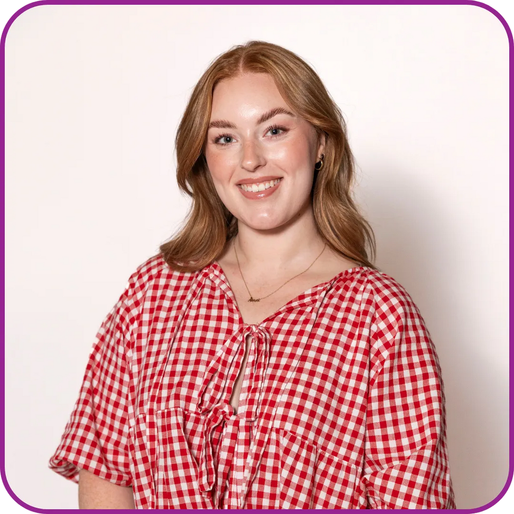 Woman wearing a red and white checkered shirt against a plain background