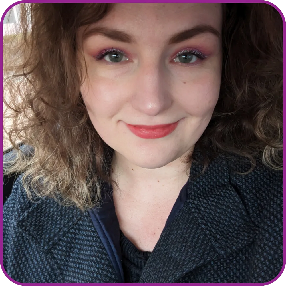 Close-up of a person with curly hair wearing a dark jacket.