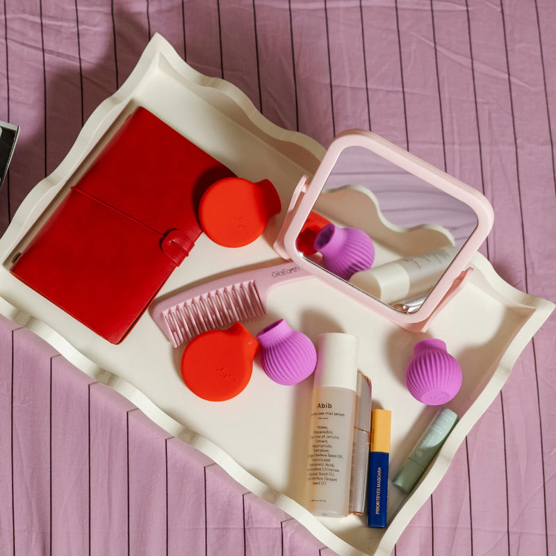 ByStorm Betty and Margie, makeup grip adaptive tools with beauty products flatlay on tray.