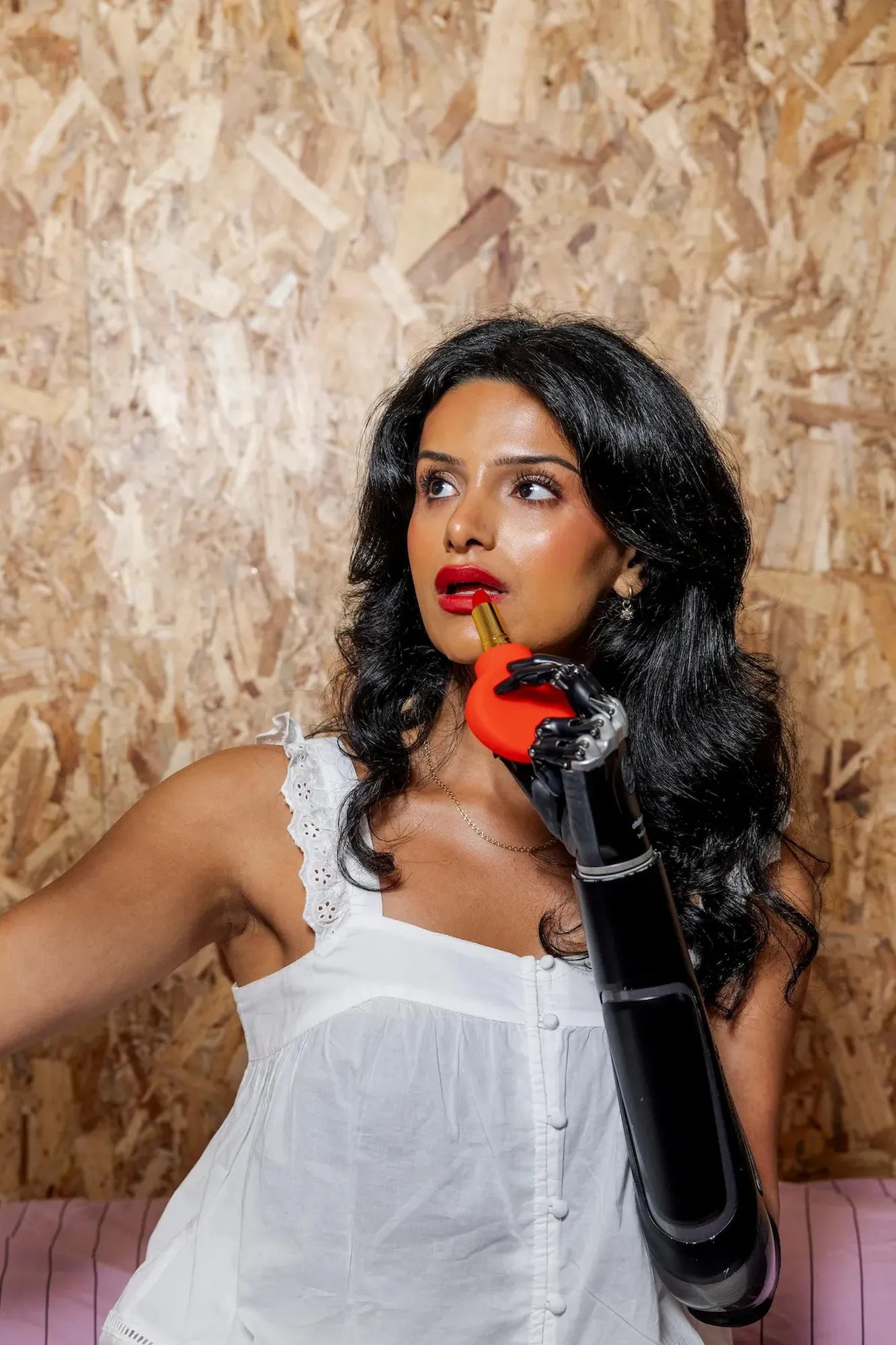 ByStorm Margie red paddle grip adaptive makeup tool used with prosthetic arm to apply lipstick