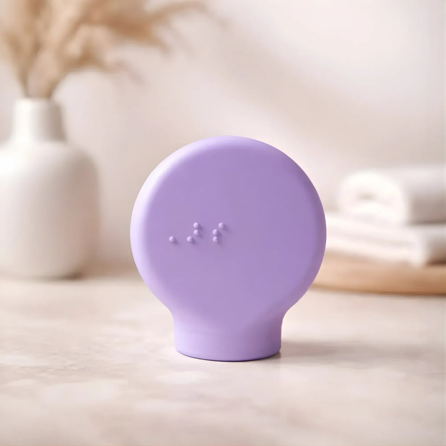 Margie, a lilac paddle-shaped accessible makeup tool by ByStorm designed for people with limited grip strength